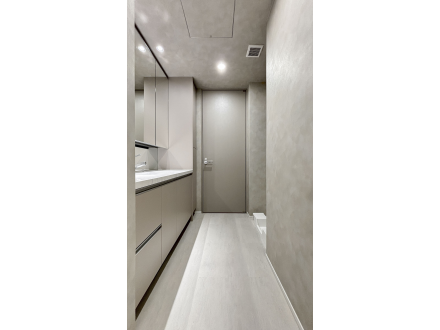 シンプルでモダンな廊下または通路の interior, 壁と床は淡い色調で統一されている。