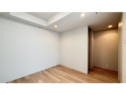 空の部屋、白い壁と木のフローリング、天井に埋め込み照明