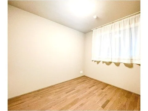 空の部屋、白い壁と木の床、窓に白いカーテン