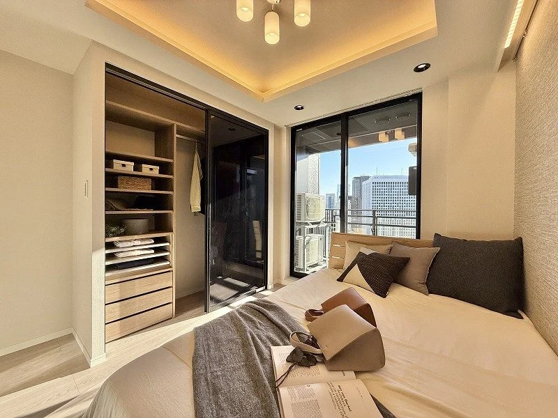 日当たりの良い現代的な寝室、窓から都市の景色が見える