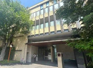 建物の入り口付近に人と自転車がある都市の風景
