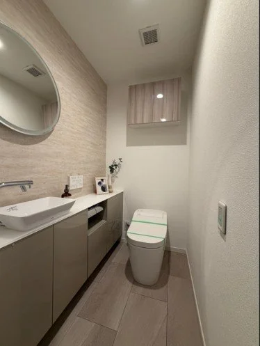 シンプルなモダンなトイレルーム、洗面台と便座、鏡と小さな収納棚付き