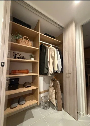 クローゼットの中に衣服、帽子、バッグ、ボックス、装飾品が整理された棚。