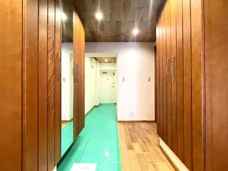木製の扉とクロス張りの壁がある室内の廊下