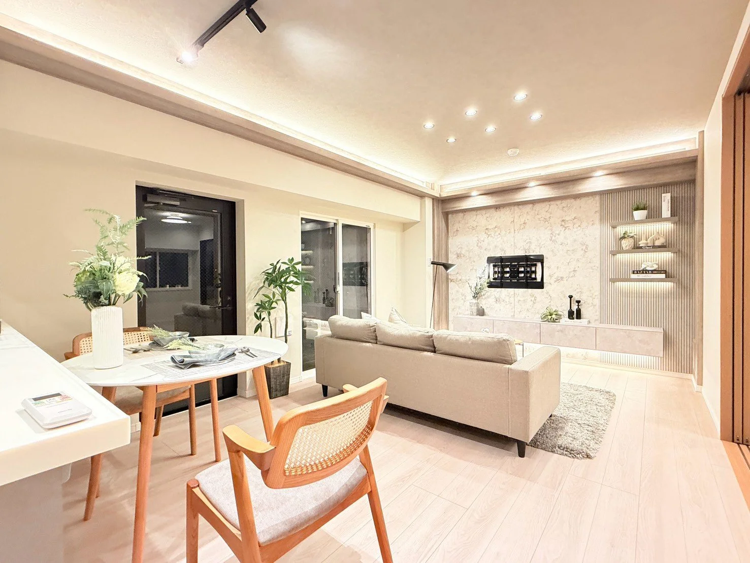 モダンなリビングルームの interior with ソファー, ダイニングテーブル, 植物, スマートテレビ, おしゃれな照明と棚がある