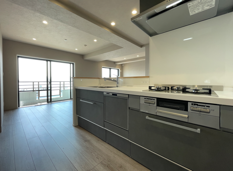 キッチンとリビングルームが見える、新しいマンションの室内画像