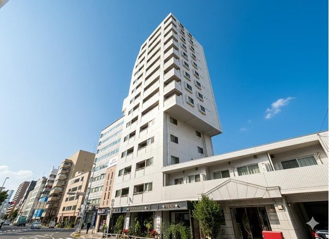 高層の白い建物と周囲の街並み、青空