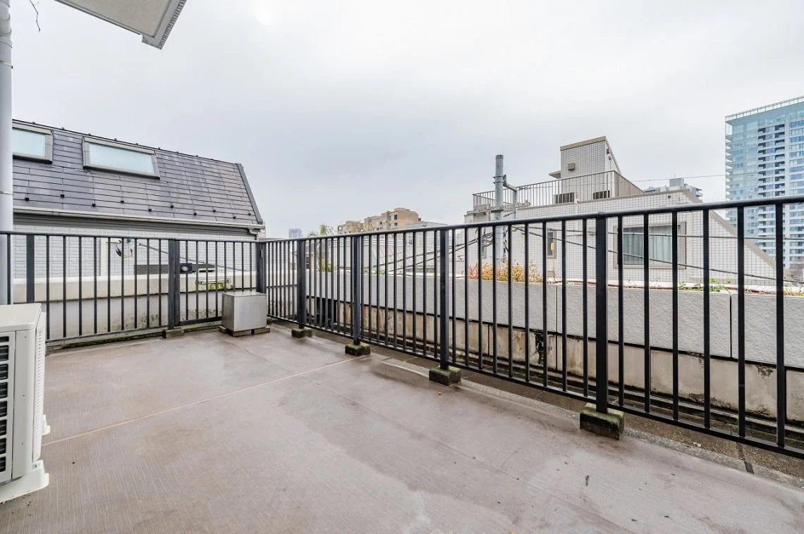 マンションのバルコニーから見える都市の建物群と空