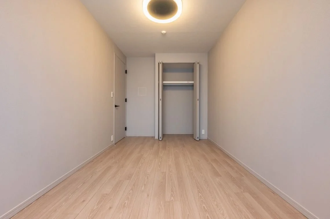 空の部屋で、左側にドア、中央にクローゼットが開いている。
