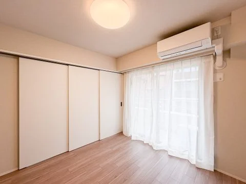 白いカーテンの窓とエアコンが設置された空間