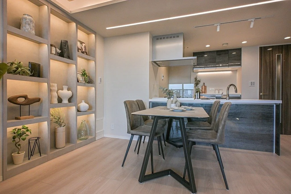 モダンなキッチンとダイニングエリア、飾り棚に植物や装飾品が配置されているリビングルームの内装