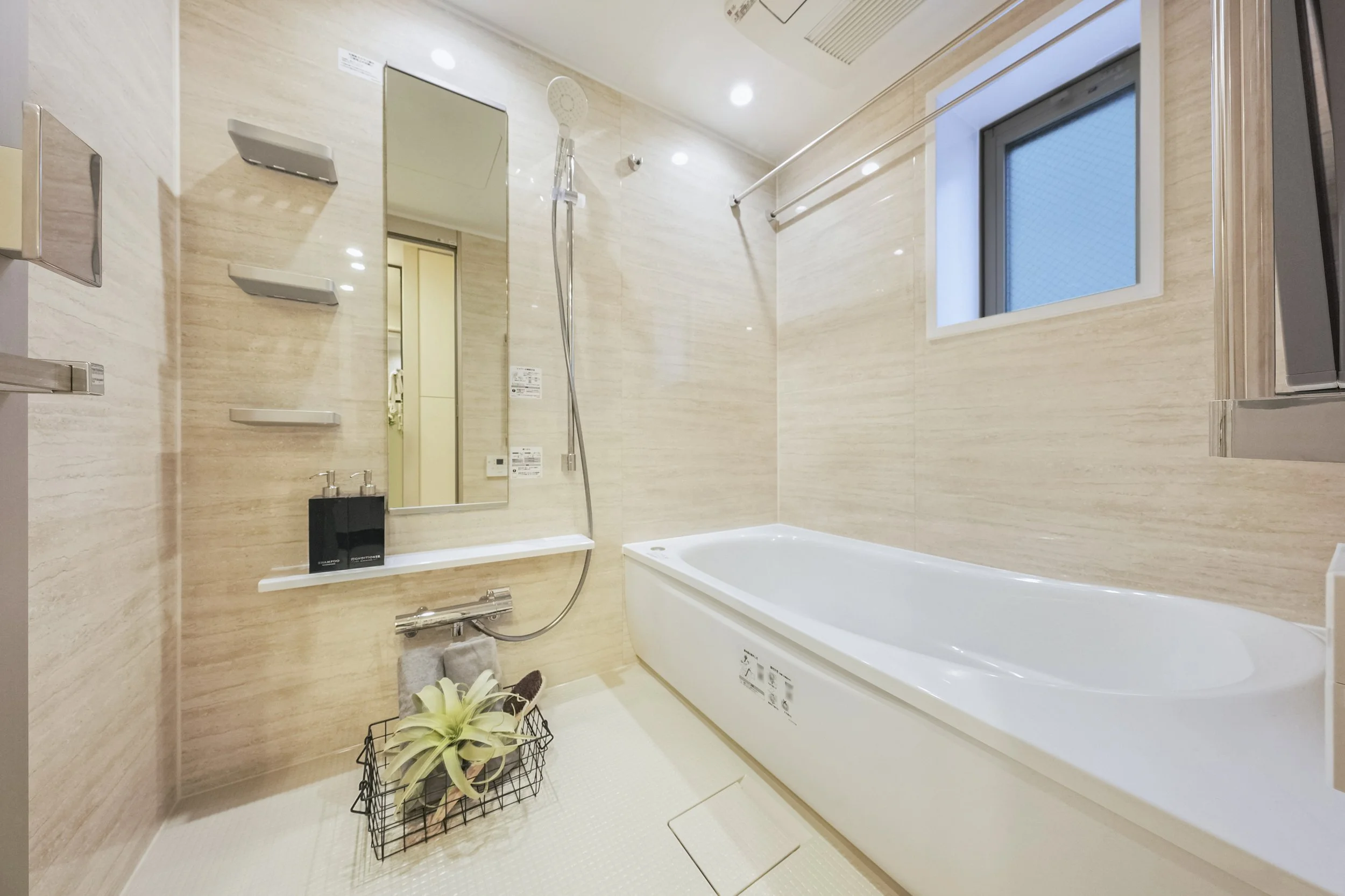 木目調の壁と白い浴槽、シャワー、鏡、窓の浴室