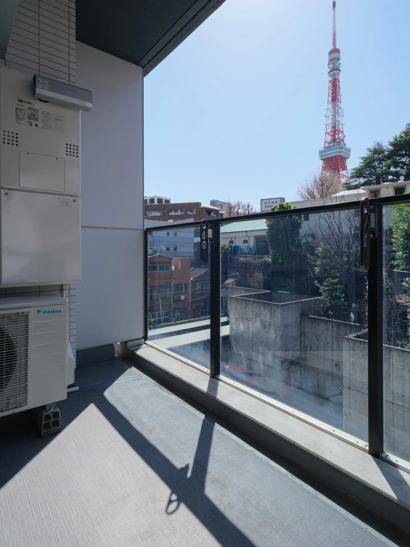 都心の高層建築のベランダから遠くに東京タワーが見える風景。