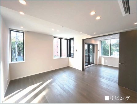 明るいリビングルーム、窓から自然光が差し込み、木製の床と白い壁。