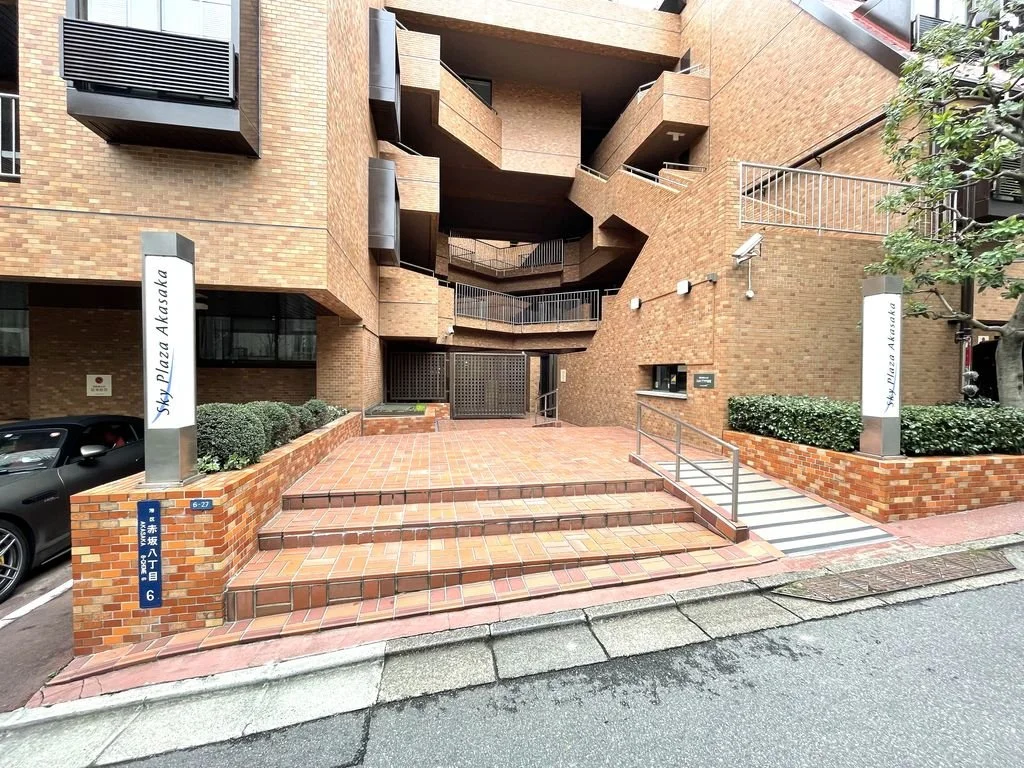 レンガ造りの建物の入り口付近の階段と通路。看板に「Sky Plaza Akasaka」と書かれている。