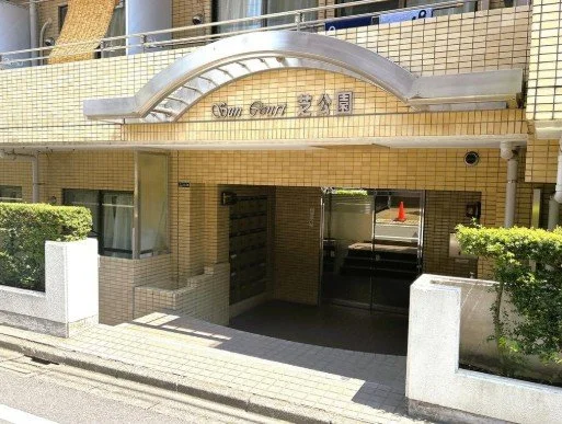 マンションの入口にあるアーチ型の看板と門。
