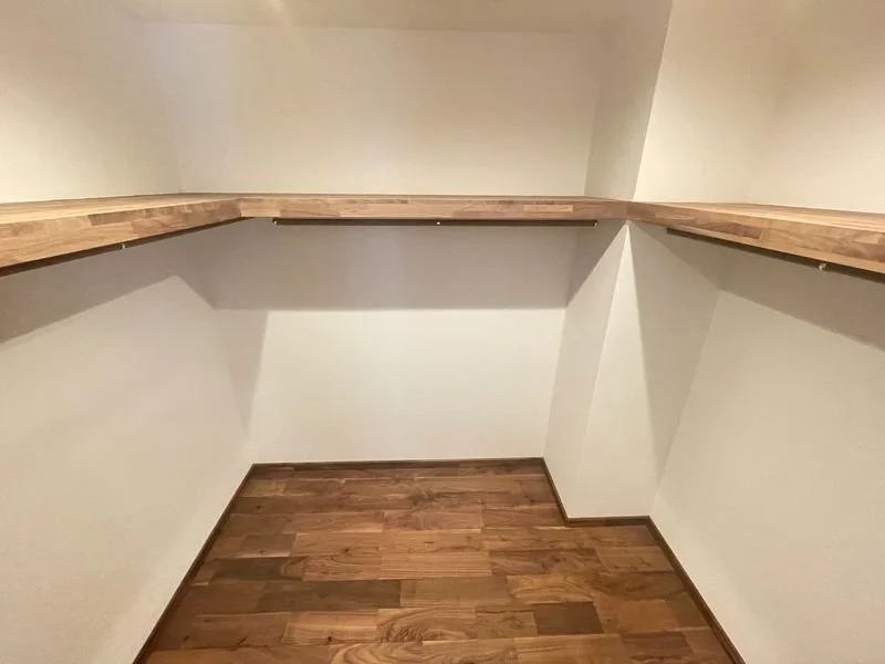 コーナーの棚と木製の床がある小さな部屋の内観