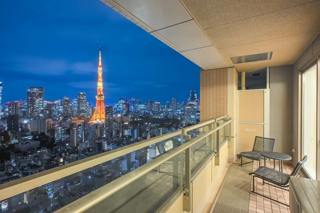高層のマンションのバルコニーから見る東京タワーと夜の都市景色