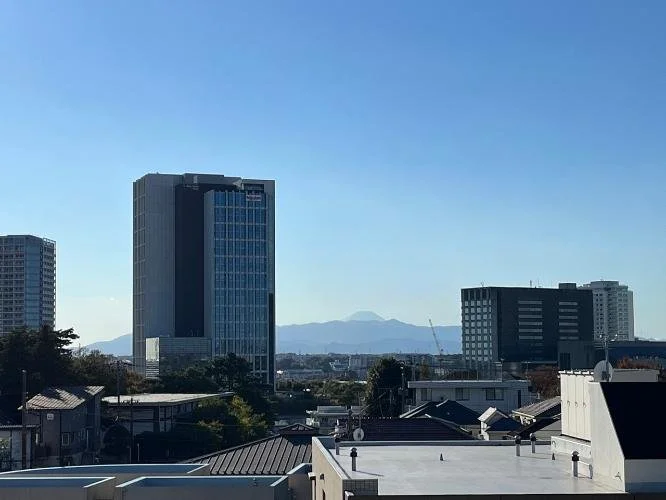 都市の高層ビルと遠くに山の見える風景