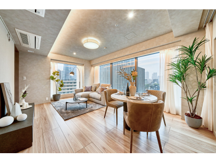 広々としたバルコニー付の高層マンションのリビングルーム。家具と観葉植物が置かれている。