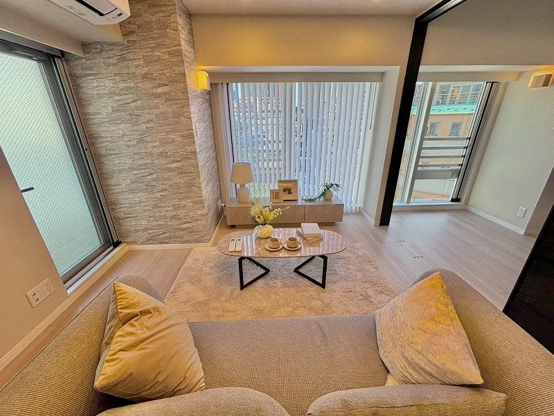 リビングルームのインテリア、ソファ、コーヒーテーブル、窓側のカーテンと景色が見える