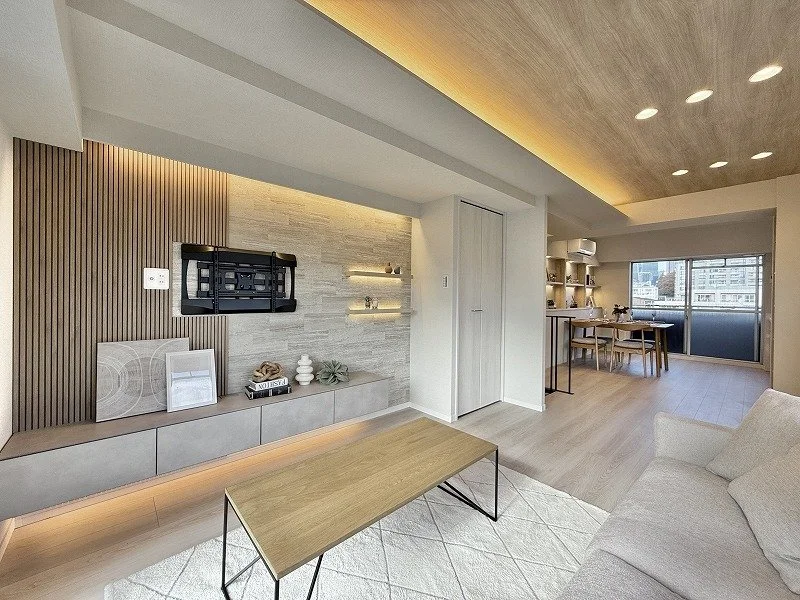 モダンなリビングルームのインテリア、木製の天井と床、白いソファとコーヒーテーブル、壁に棚や装飾品が配置されている。