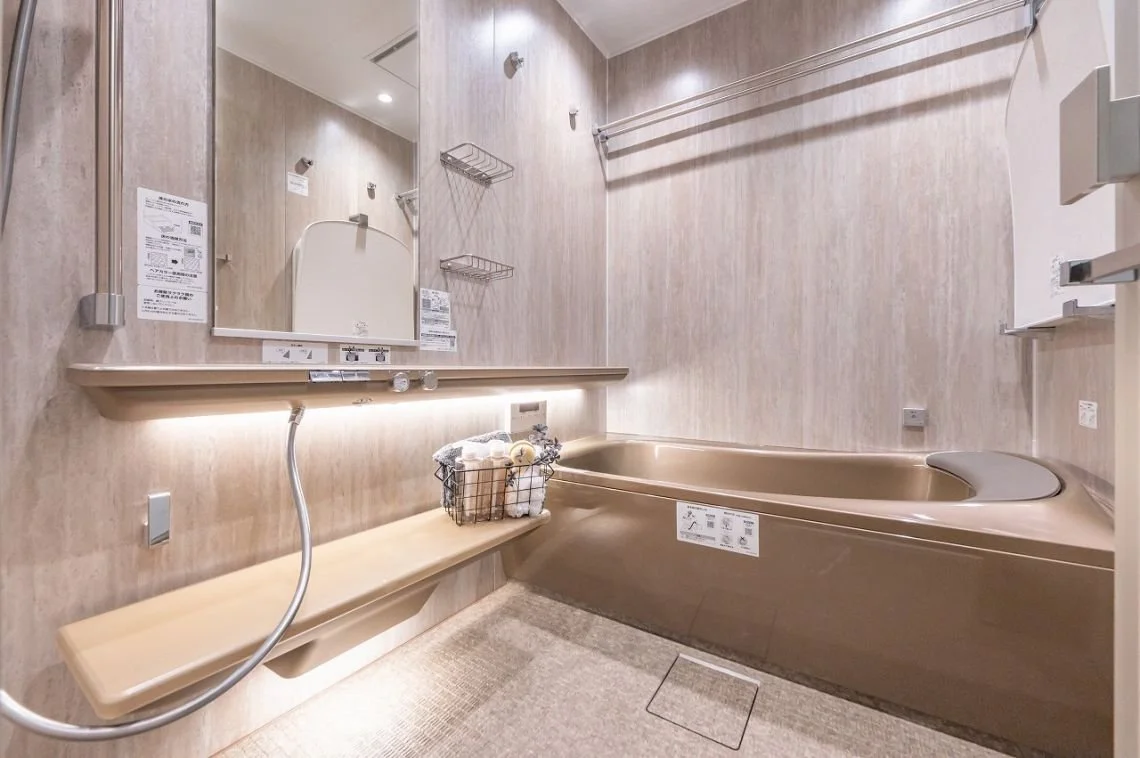 浴室の洗い場と浴槽があるモダンなバスルームの画像です。鏡、棚、シャワー、バス用品のバスケットも見えます。