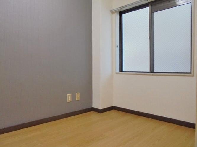 空の部屋で、壁には2つのコンセントと大きな窓がある。