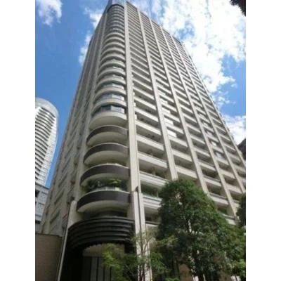 高層の白いマンションビルと青空