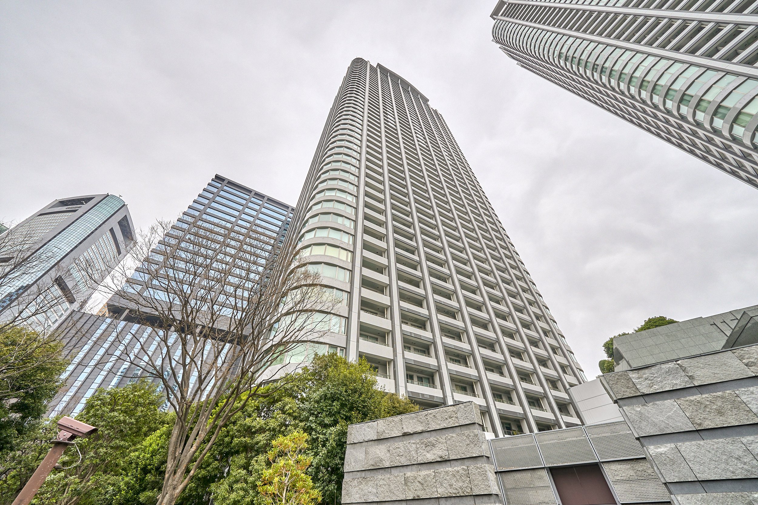高層ビル群を見上げる角度からの写真。中央に高いビルとその周囲にいくつかの建物が映っている。