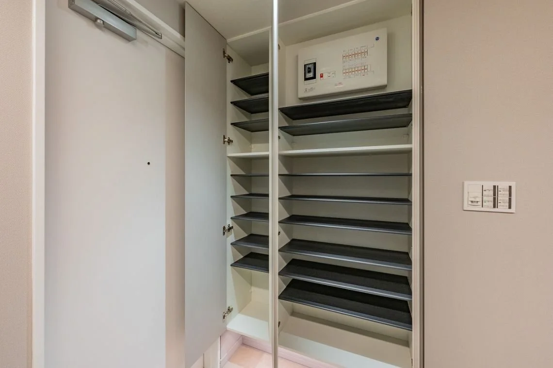 靴箱の棚と電気配線の制御盤があるクローゼット