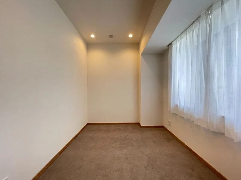 白い壁とカーテンがある空き部屋