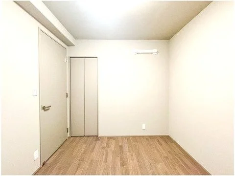 空の部屋、木製の床と白い壁、ドアとクローゼットあり