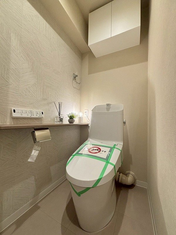 新しいトイレで、清掃未済のため緑のテープと注意書きが貼られている。