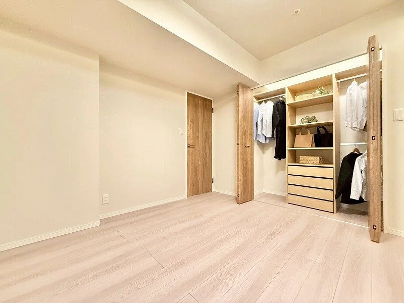 空のクローゼットと木製の棚。シャツやバッグが収納されている。