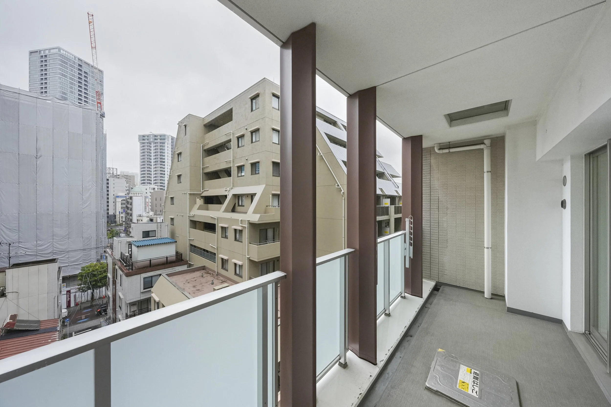 都市の高層ビルと住宅が見えるバルコニーの写真