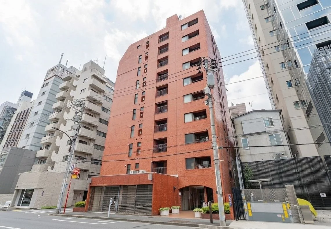赤い多層ビルと周囲の高層ビルが見える都市の風景