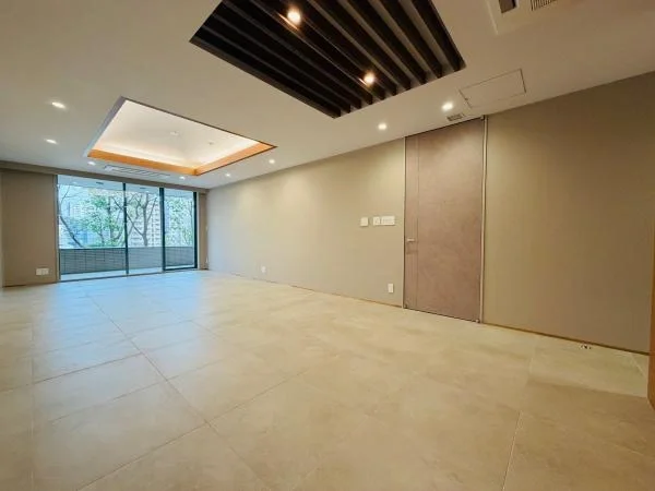 空のリビングルーム、窓の外に木々が見える