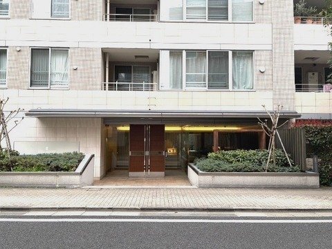 都市のホテルやマンションのエントランス、前に歩道。