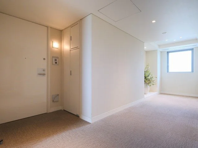 白い壁とドア、窓付きの明るい部屋の内部