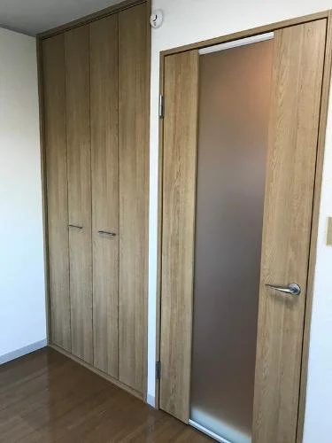 木製のクローゼットとガラス入りのドアがある室内の風景