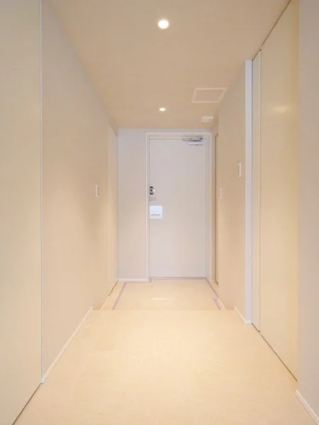 シンプルな廊下の先にドアがあり、天井に照明がついている。