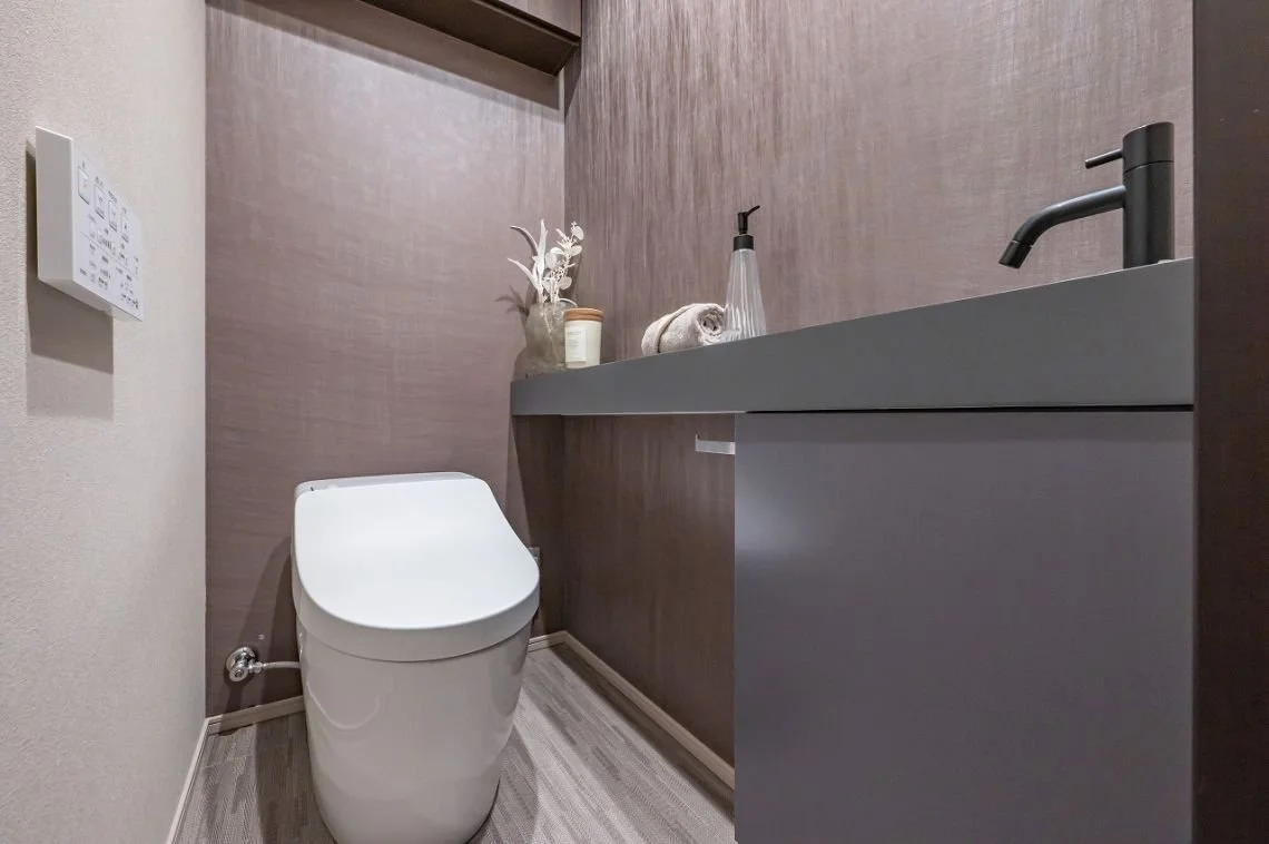 トイレと洗面台のある現代的なトイレルーム。