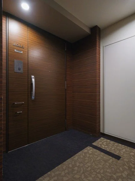 エレベーターの扉とインターホンが設置されたエントランスホールの壁面。
