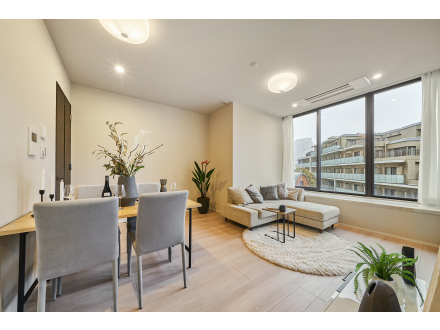 モダンなリビングルームとダイニングルーム、ソファ、植物、大きな窓から都市の景色を臨む