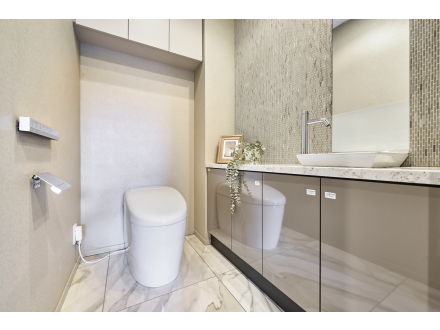 白い便器と洗面台があるシンプルなトイレの内装