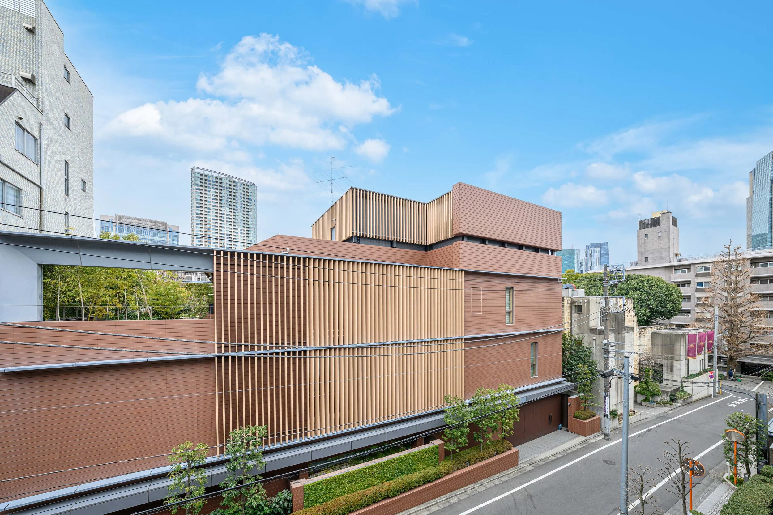 都市の風景、茶色の建物と道路、背景に高層ビル群と青空