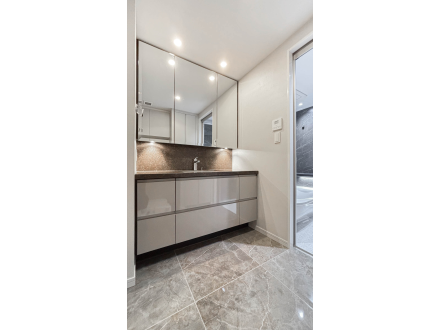 洗面台と鏡、照明があるモダンなバスルームの一角