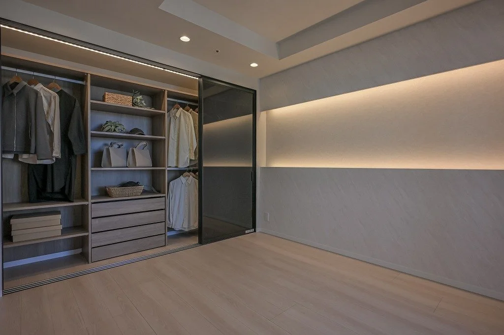 クローゼットの中に洋服やバッグなどが整理されているシンプルでモダンな室内の空間