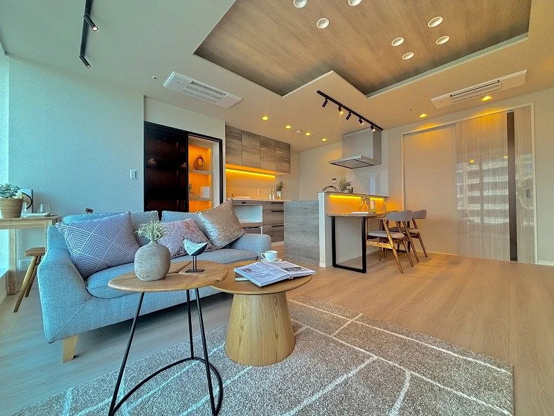 モダンなリビングルームとキッチンエリアの interior scene with a sofa, coffee table, kitchen appliances, and dining area